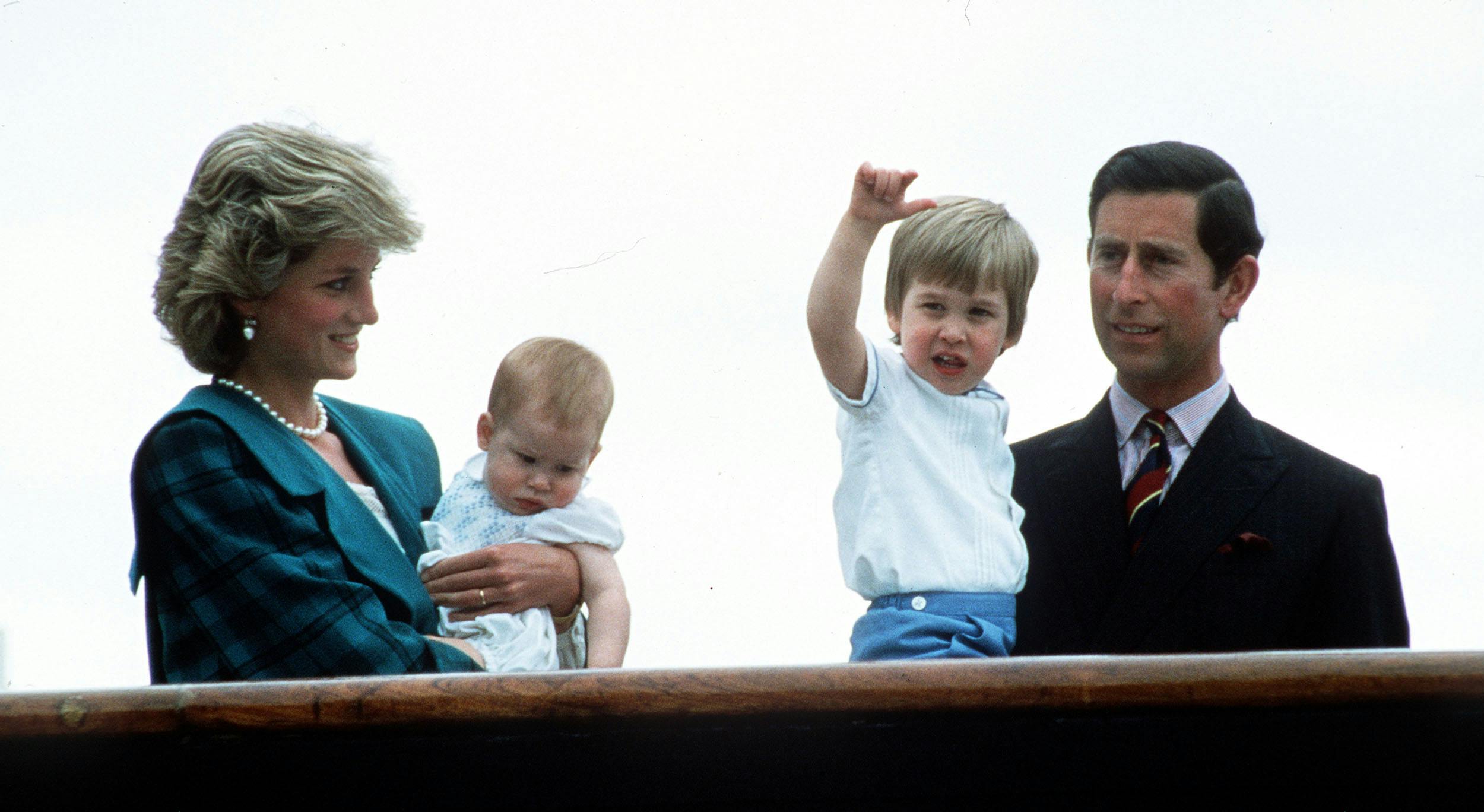 Familien står på deres yacht og vinker til de fremmødte. Prins Harry i armene på prinsesse Diana og prins William i armene på prins Charles.
