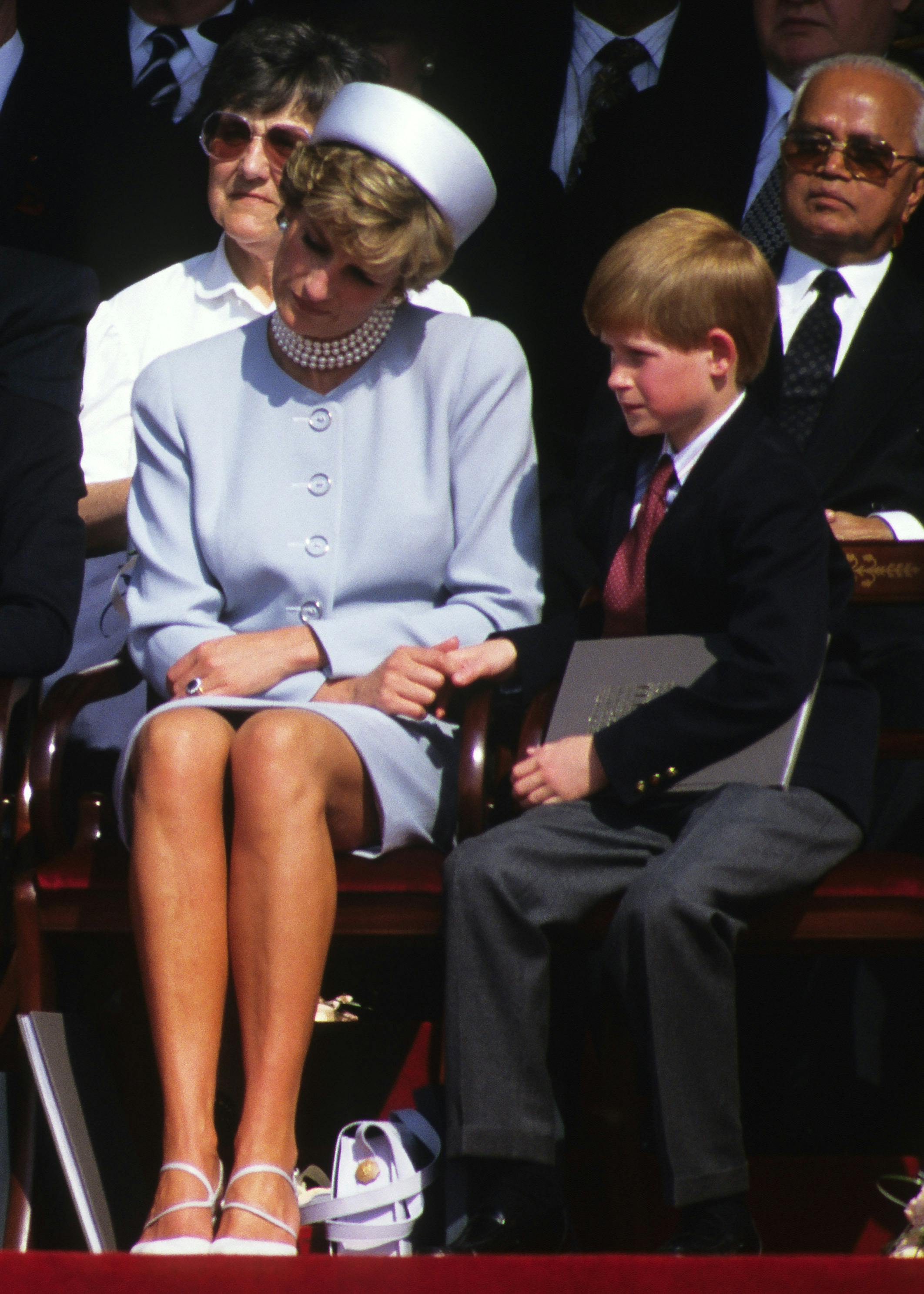 Prinsesse Diana holder prins Harrys hånd under en offentlig begivenhed. 