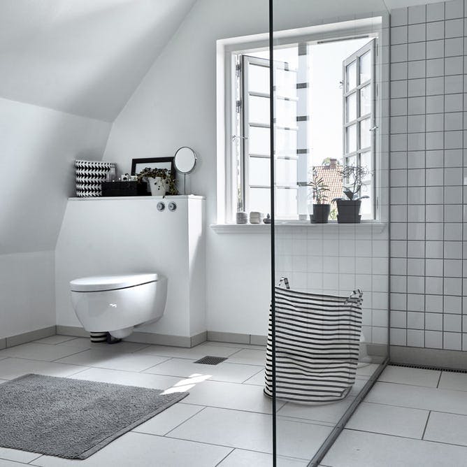 Stilrent og enkelt badeværelse med væghængt toilet. 