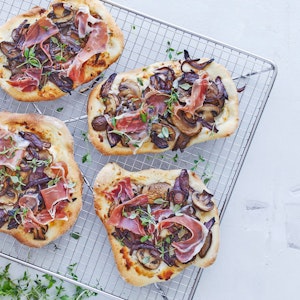 Mini-pizzaer med gedeost, svampe og sortfodsskinke 