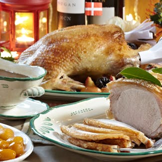 Julemad: And, flæskesteg, brunede kartofler og sovs på bord 
